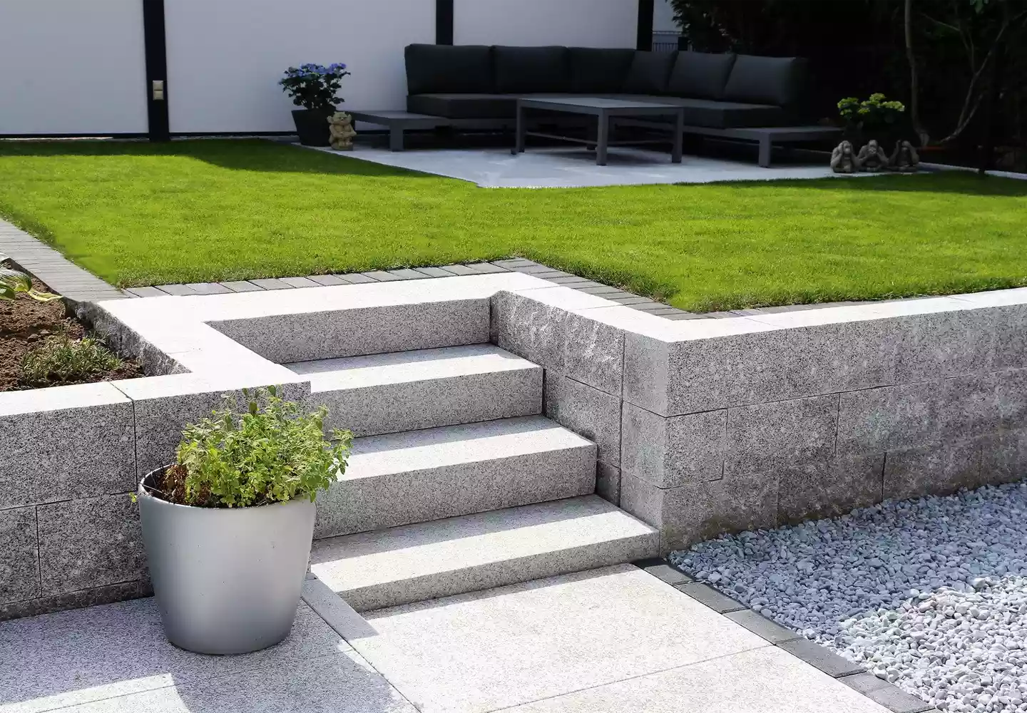 Natursteinweg mit Terrassenumrandung und Treppen aus Naturstein - Rollrasen, Gartenmöbel und Blumenbeet mit nährstoffreicher Blumenerde